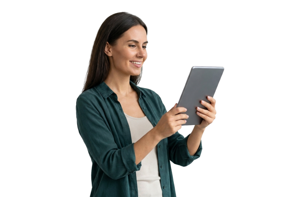 Eine lächelnde Frau mit langen dunklen Haaren, die ein Tablet in der Hand hält und darauf schaut. Sie trägt ein grünes Shirt über einem hellen Oberteil und steht vor einem schlichten weißen Hintergrund.