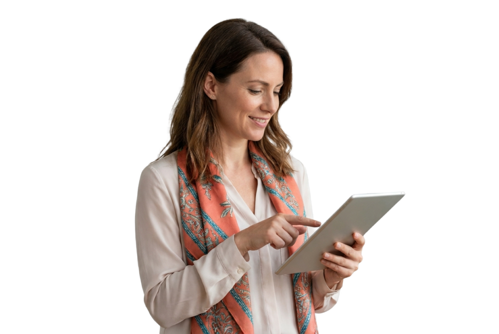 Eine lächelnde Frau in einer weißen Bluse und einem gemusterten Schal hält ein Tablet in der Hand und bedient es vor einem schlichten weißen Hintergrund.