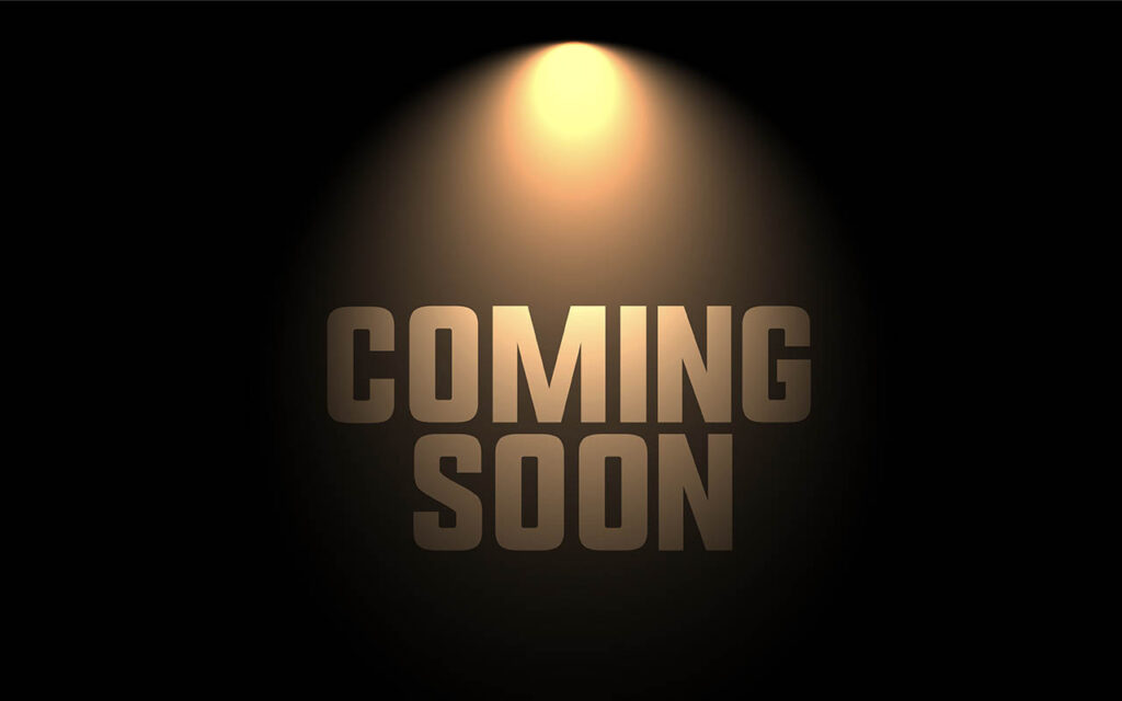 Die Worte „COMING SOON“ werden vor einem ansonsten dunklen Hintergrund von einem Scheinwerfer beleuchtet.